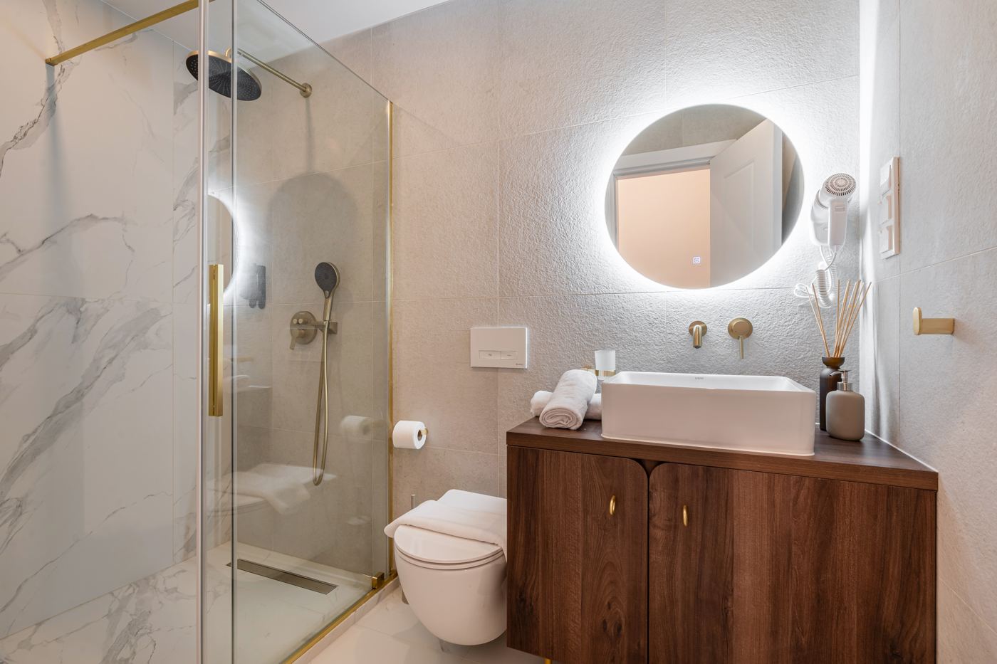 Bathroom with walk-in shower and illuminated round mirror